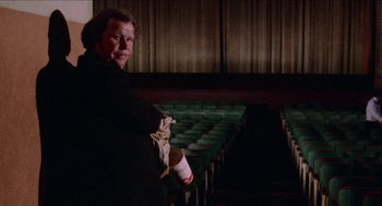 Movie still from “Mikey and Nicky” (1976), directed by Elaine May – A man standing in front of an empty auditorium; Medium shot, Low angle