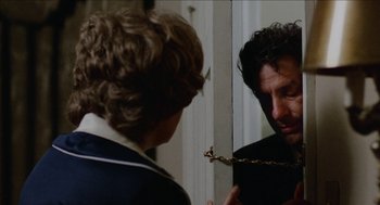 Movie still from “Mikey and Nicky” (1976), directed by Elaine May – A man is looking in the mirror while holding a branch in his mouth; Close Up shot, Over the shoulder angle