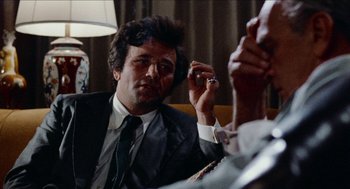 Movie still from “Mikey and Nicky” (1976), directed by Elaine May – A man smoking a cigarette while sitting in a chair; Close Up shot, Over the shoulder angle