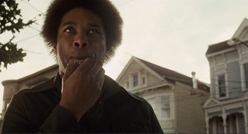 Movie still from “Milk” (2008), directed by Gus Van Sant – A person holding a knife to his mouth; Close Up shot, Low angle