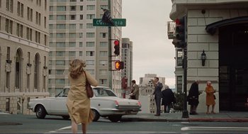 Movie still from “Milk” (2008), directed by Gus Van Sant – A woman crossing the street at a crosswalk in a city; Extreme Wide shot, High angle
