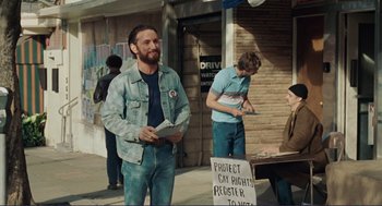Movie still from “Milk” (2008), directed by Gus Van Sant – A group of men standing on the side of the street; Medium shot, Over the shoulder angle