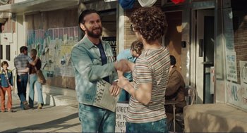 Movie still from “Milk” (2008), directed by Gus Van Sant – Two people shaking hands on a street corner; Medium shot, Over the shoulder angle