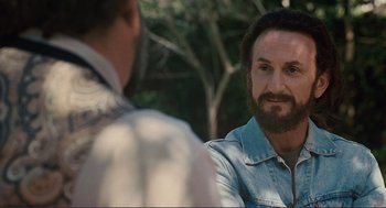 Movie still from “Milk” (2008), directed by Gus Van Sant – A man with a beard is talking to another man in front of a tree; Close Up shot, Over the shoulder angle