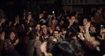 Movie still from “Milk” (2008), directed by Gus Van Sant – A group of people taking pictures with their cell phones; Wide shot, High angle