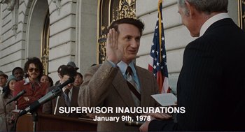 Movie still from “Milk” (2008), directed by Gus Van Sant – A man is sworn in at an inauguration ceremony; Medium shot, Low angle