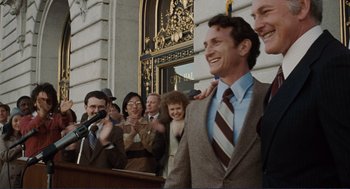 Movie still from “Milk” (2008), directed by Gus Van Sant – A group of people standing in front of a building; Medium shot, Low angle