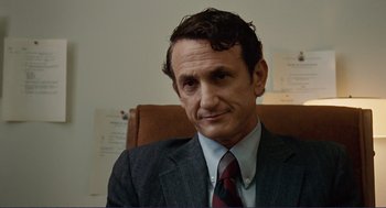 Movie still from “Milk” (2008), directed by Gus Van Sant – A person wearing a suit and tie; Close Up shot, Over the shoulder angle