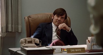 Movie still from “Milk” (2008), directed by Gus Van Sant – A man sitting at a desk in front of a phone; Medium shot, Over the shoulder angle