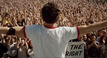 Movie still from “Milk” (2008), directed by Gus Van Sant – A crowd of people raising their hands in front of a man; Wide shot, High angle