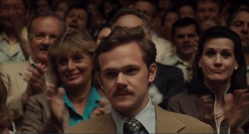 Movie still from “Milk” (2008), directed by Gus Van Sant – A man in a suit and tie in front of an audience; Close Up shot, Over the shoulder angle