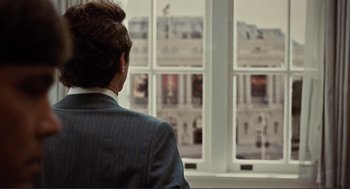 Movie still from “Milk” (2008), directed by Gus Van Sant – A man in a suit looking out of a window; Medium shot, Over the shoulder angle
