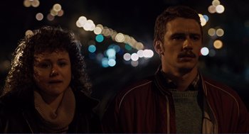 Movie still from “Milk” (2008), directed by Gus Van Sant – A man and a woman standing next to each other in the dark; Close Up shot, Over the shoulder angle