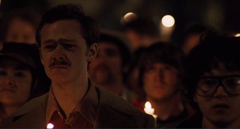Movie still from “Milk” (2008), directed by Gus Van Sant – A group of people standing in the dark holding lit candles; Close Up shot, Low angle