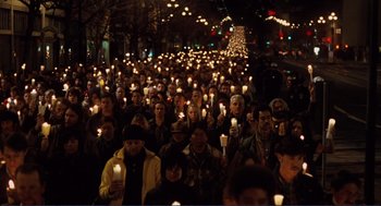 Movie still from “Milk” (2008), directed by Gus Van Sant – A large group of people holding lit candles in the dark; Wide shot, High angle