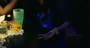 Movie still from “Millennium Mambo” (2001), directed by Hsiao-Hsien Hou – A person is holding a remote control in their hand; Extreme Close Up shot, High angle