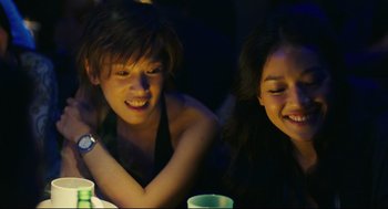 Movie still from “Millennium Mambo” (2001), directed by Hsiao-Hsien Hou – Two young people sitting at a table with drinks; Medium shot, Over the shoulder angle