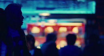 Movie still from “Millennium Mambo” (2001), directed by Hsiao-Hsien Hou – A group of people standing in front of a building lit up; Close Up shot, Over the shoulder angle