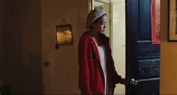 Movie still from “Millennium Mambo” (2001), directed by Hsiao-Hsien Hou – A young woman wearing a red jacket and a head scarf; Medium shot, Over the shoulder angle