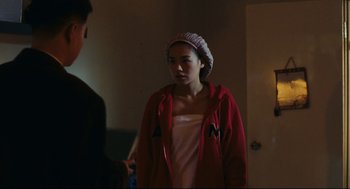 Movie still from “Millennium Mambo” (2001), directed by Hsiao-Hsien Hou – A woman wearing a red jacket standing next to a man; Medium shot, Over the shoulder angle