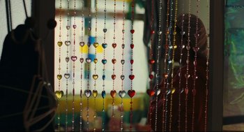 Movie still from “Millennium Mambo” (2001), directed by Hsiao-Hsien Hou – A bunch of beads hanging in front of a window; Close Up shot, Over the shoulder angle