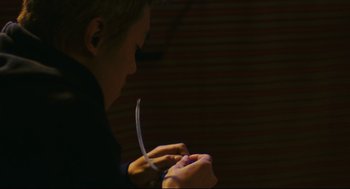 Movie still from “Millennium Mambo” (2001), directed by Hsiao-Hsien Hou – A young boy is playing with an electronic device; Close Up shot, Low angle