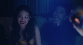 Movie still from “Millennium Mambo” (2001), directed by Hsiao-Hsien Hou – A man and a woman sitting next to each other on a couch; Medium shot, Over the shoulder angle