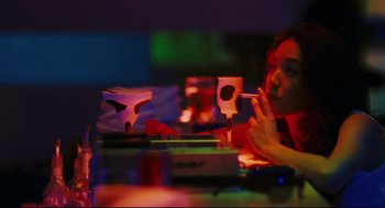 Movie still from “Millennium Mambo” (2001), directed by Hsiao-Hsien Hou – A man sitting at a table in front of boxes; Medium shot, Low angle