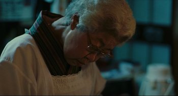 Movie still from “Millennium Mambo” (2001), directed by Hsiao-Hsien Hou – An older man wearing glasses looking down at his face; Close Up shot, Low angle