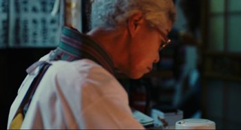 Movie still from “Millennium Mambo” (2001), directed by Hsiao-Hsien Hou – An older man sitting at a dining table; Close Up shot, Over the shoulder angle