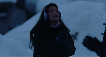Movie still from “Millennium Mambo” (2001), directed by Hsiao-Hsien Hou – A woman wearing headphones while standing in the snow; Medium shot, Over the shoulder angle