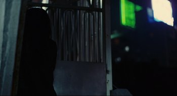 Movie still from “Millennium Mambo” (2001), directed by Hsiao-Hsien Hou – A person standing in front of a metal gate; Medium shot, Low angle
