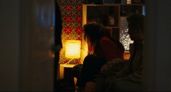 Movie still from “Millennium Mambo” (2001), directed by Hsiao-Hsien Hou – A woman sitting on a couch in front of a table lamp; Medium shot, Over the shoulder angle