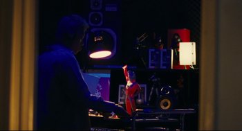 Movie still from “Millennium Mambo” (2001), directed by Hsiao-Hsien Hou – A man is playing the piano in the dark; Medium shot, Low angle