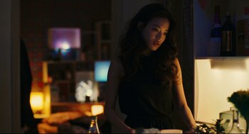 Movie still from “Millennium Mambo” (2001), directed by Hsiao-Hsien Hou – A woman standing in a dark room with a bottle of beer; Medium shot, Over the shoulder angle