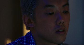 Movie still from “Millennium Mambo” (2001), directed by Hsiao-Hsien Hou – A person with a blue shirt on; Close Up shot, High angle