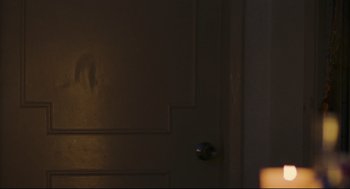 Movie still from “Millennium Mambo” (2001), directed by Hsiao-Hsien Hou – A dark room with a door and a light on it; Close Up shot, Over the shoulder angle
