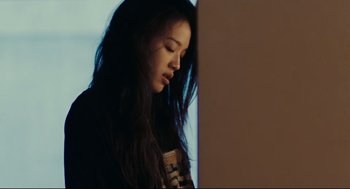 Movie still from “Millennium Mambo” (2001), directed by Hsiao-Hsien Hou – A woman with long black hair leaning against a wall; Close Up shot, Low angle
