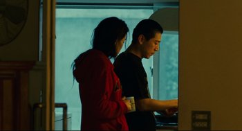 Movie still from “Millennium Mambo” (2001), directed by Hsiao-Hsien Hou – A man and a woman standing next to each other in front of a window; Medium shot, Low angle