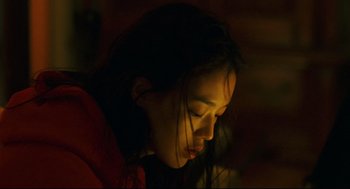 Movie still from “Millennium Mambo” (2001), directed by Hsiao-Hsien Hou – A young woman is looking down at her face; Close Up shot, Low angle