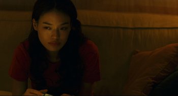 Movie still from “Millennium Mambo” (2001), directed by Hsiao-Hsien Hou – A woman sitting on a couch looking at the camera; Close Up shot, Over the shoulder angle