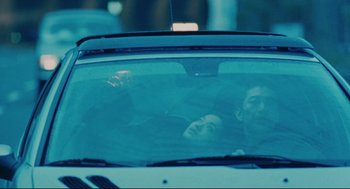 Movie still from “Millennium Mambo” (2001), directed by Hsiao-Hsien Hou – A man and a woman in the back seat of a car; Medium shot, Over the shoulder angle