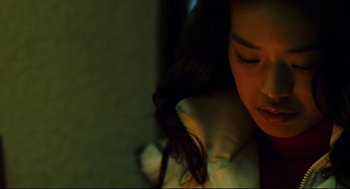Movie still from “Millennium Mambo” (2001), directed by Hsiao-Hsien Hou – A woman sitting in a room with her eyes closed; Close Up shot, High angle