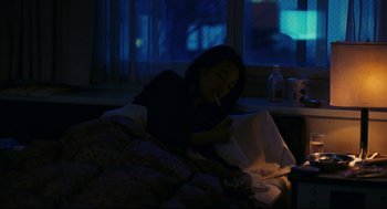 Movie still from “Millennium Mambo” (2001), directed by Hsiao-Hsien Hou – A woman sitting in a bed with a cigarette in her mouth; Medium shot, High angle