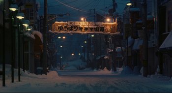 Movie still from “Millennium Mambo” (2001), directed by Hsiao-Hsien Hou – A street sign hanging over a snowy street at night; Extreme Wide shot, Low angle