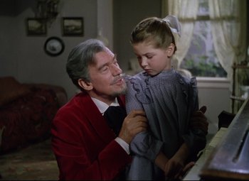 Movie still from “Million Dollar Mermaid” (1952), directed by Mervyn LeRoy – An older man holding a little girl in his arms; Medium shot, Low angle