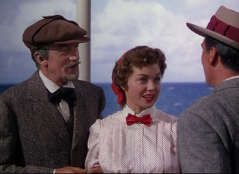 Movie still from “Million Dollar Mermaid” (1952), directed by Mervyn LeRoy – An older man and a young woman standing next to each other on a boat; Medium shot, Over the shoulder angle