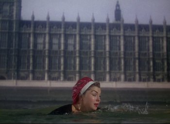 Movie still from “Million Dollar Mermaid” (1952), directed by Mervyn LeRoy – A woman swimming in a body of water near a building; Extreme Wide shot, Low angle