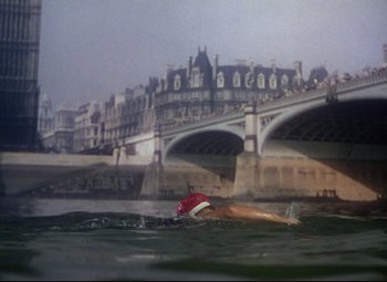 Movie still from “Million Dollar Mermaid” (1952), directed by Mervyn LeRoy – A man swimming in a body of water near a bridge; Extreme Wide shot, High angle