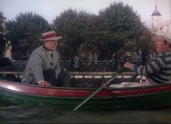Movie still from “Million Dollar Mermaid” (1952), directed by Mervyn LeRoy – A man in a hat is sitting in a small boat; Wide shot, High angle